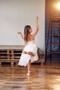 Young ballerina in white tutu practicing dance moves. Royalty Free Stock Photo