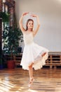 Young ballerina in white tutu practicing dance moves. Royalty Free Stock Photo