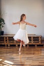 Young ballerina in white tutu practicing dance moves. Royalty Free Stock Photo