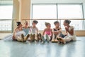 Young ballerinas sitting on floor and embracing. Royalty Free Stock Photo