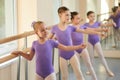 Young ballerinas training at ballet barre.