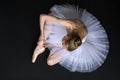 Young ballet dancer tying pointe sitting on the