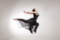 Young ballet dancer wearing black transparent dress jumping