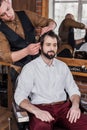 young barber combing hair of customer Royalty Free Stock Photo