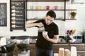 Young barista male work in a coffee shop and making coffee. Barista making cappuccino, bartender preparing coffee drink. Portrait Royalty Free Stock Photo