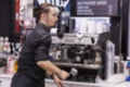 Young barista prepares coffee. Modern service. Blurred