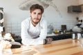 Young barista standing at the counter in restaurant