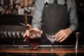 Young barman making a fresh alcoholic cocktail into the cocktail glass Royalty Free Stock Photo