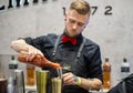 Young barman prepares Bloody Mary cocktail