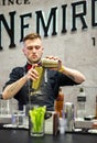 Young barman prepares Bloody Mary cocktail