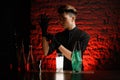 Young bartender at dark bar puts on black medical gloves