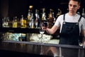 A young bartender pours champagne into a glass from a bottle on the bar Royalty Free Stock Photo