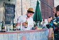 Young bartender pours sparkling wine in glasses