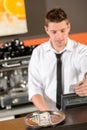 Young bartender in uniform taking cash dollar