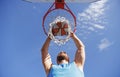 Young basketball player dunking basketball on outdoor court. Royalty Free Stock Photo