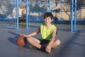 Young basketball player sitting on the court Royalty Free Stock Photo