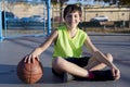 Young basketball player sitting on the court Royalty Free Stock Photo