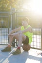 Young basketball player sitting on the court Royalty Free Stock Photo