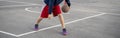 young basketball player training to dribble outdoor on the asphalt court in summer seasons