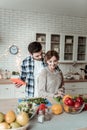 Young beaming pretty woman with big earrings and her husband cutting greens together