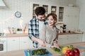 Young beaming pretty woman with big earrings and her husband feeling great