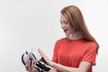 Young beaming woman feeling excited while holding virtual reality glasses