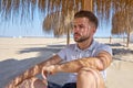 Young beard man in a beach under parasol