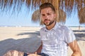 Young beard man in a beach under parasol