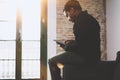 Young bearded African man using laptop while sitting on sofa at his modern home office.Concept of people working with Royalty Free Stock Photo