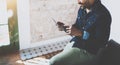 Young bearded African man using laptop while sitting on sofa at his modern home office.Concept of people working with Royalty Free Stock Photo