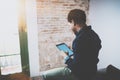 Young bearded African man using laptop while sitting on sofa at his modern home office.Concept of people working with Royalty Free Stock Photo