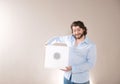 Young attractive man  holding white portable bluetooth speaker on gray background Royalty Free Stock Photo