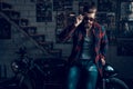 Young Biker in Sunglasses on Motorcycle in Garage.