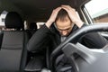 Young bearded business man sitting in car very upset and stressed after hard failure and moving in traffic jam Royalty Free Stock Photo