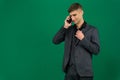 emotions of a handsome man guy on a green background chromakey. phone in hand talk dial SMS online call gadget boss work Royalty Free Stock Photo