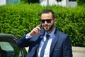 Young bearded businessman in elegant suit with phone