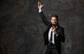 A young bearded businessman in a suit looks at the phone and rejoices. successful man saw good news on the phone, joy Royalty Free Stock Photo