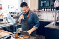 Young bearded Caucasian male man cashier barista in restaurant cafe at work. Royalty Free Stock Photo