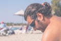 Young bearded Caucasian man with sunglasses enjoying the sun on the beach