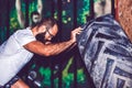 Young bearded fitness man moving large tire in the crossfit gym