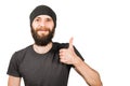 Young bearded guy in hat, smiles and show thumb up. Isolated on white background Royalty Free Stock Photo