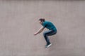 Young bearded guy sortsman jumping on the background of a pink street wall