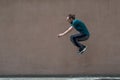 Young bearded guy sortsman jumping on the background of a pink street wall