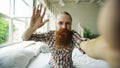 Young bearded man using tablet computer having video chat sitting in bed at home Royalty Free Stock Photo