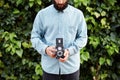 Young bearded hipster taking photo with TLR camera