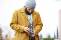 Young bearded hipster taking photo with TLR camera