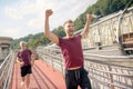 Young bearded male raising both hands, winning running race