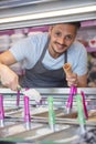young bearded man in apron seling ice cream