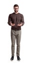 A young bearded man in cargo pants looks down on his both hands cupped as if holding something. Royalty Free Stock Photo