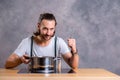 Young bearded man with cooking pot and egg whish